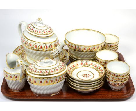 A Coalport Porcelain Tea Service, circa 1800, of wrythen fluted form, painted with red and gilt harebells, comprising a teapo