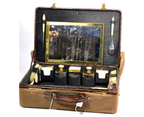A Crocodile Skin Vanity Case, early 20th century, fitted and containing gilt metal mounted bottles, brushes, mirrors, a shoe 