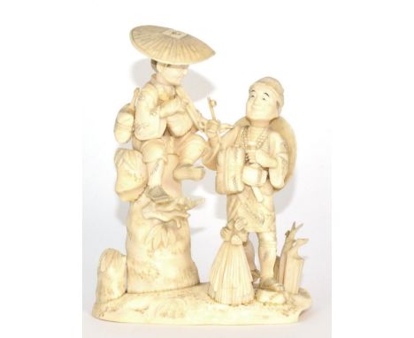 A Japanese Ivory Okimono, Meiji period, as a boy sitting on a rock smoking a pipe, a man with a further pipe at his side, on 