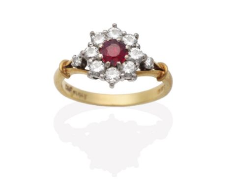 An 18 Carat Gold Ruby and Diamond Cluster Ring, a round cut ruby in a claw setting within a border of round brilliant cut dia