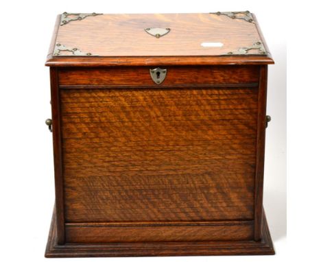 An Edwardian White Metal Mounted Oak Smoker's Compendium, with hinged top and tambour front enclosing drawers, a pipe rack, c