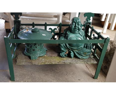A cast iron fire grate with seated Buddha and metal incense burner 