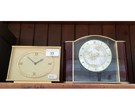 A brass mantel clock by Imhof together with a modern clock featuring a world map 