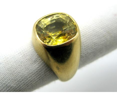 A Gent's Single Stone Ring, collet rubover set with a cushion shape yellow sapphire, stamped "585". *Goldsmiths Insurance Val