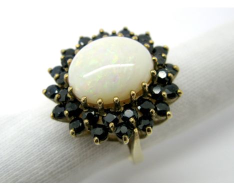 A Large 9ct Gold Opal and Sapphire Cluster Ring, oval cabochon claw set to the centre, within two row claw set border of circ