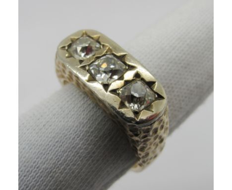 A Gent's Three Stone Diamond Ring, star rubover set to the top with three old cushion cut stones (one chipped), within textur