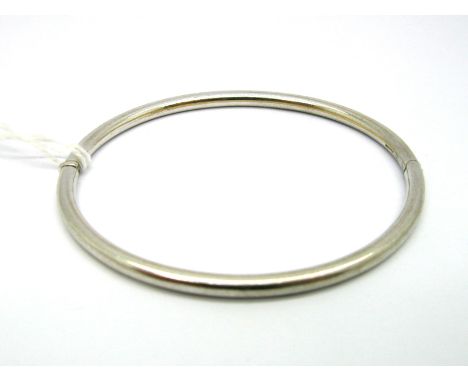 A Modern 9ct White Gold Bangle, of plain design, hinged to snap clasp. 