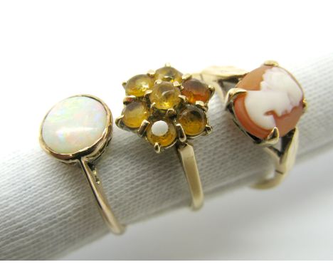 A 9ct Gold Cameo Ring, oval claw set between textured shoulders; a 9ct gold cluster dress ring and an opal single stone ring,