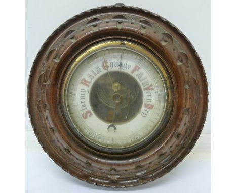 A carved walnut aneroid barometer