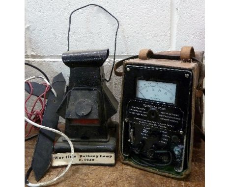 A 1940's railway lamp and wall bracket and a G.P.O. tester in a leather case