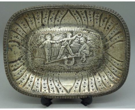 A silver dish depicting three boys playing on a see saw, marked London 1812, Rebecca Emes and Edward Barnard, width 218mm, we