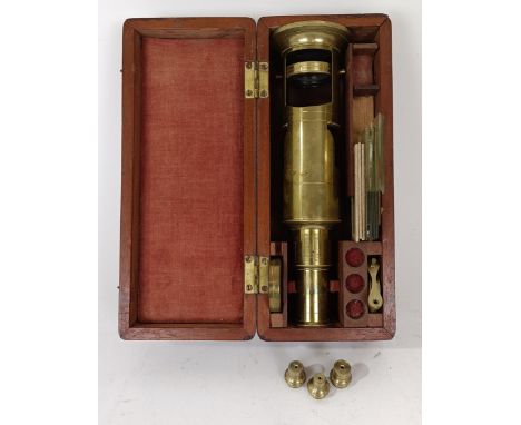 A late 19th/early 20th century brass binocular, with various slides, in a mahogany case, 23 cm wide
