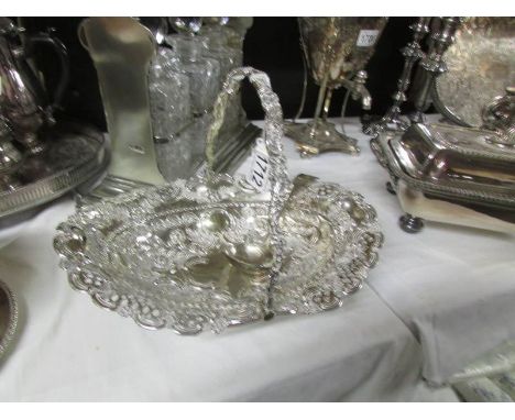 An ornate silver plate basket and a ladle.