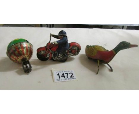 A tin plate clock work duck, a tin plate friction motor cycle and a hot air balloon spinning top.