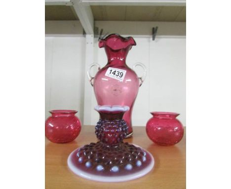 A cranberry glass vase, a pair of crackle glazed cranberry glass pots and a glass chamber candlestick.