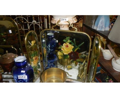 A Victorian brass triple fold fire screen with painted mirror panels.