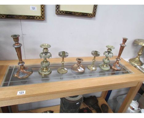 2 pairs of brass candlesticks, a pair of copper candlesticks and a brass chamber stick.