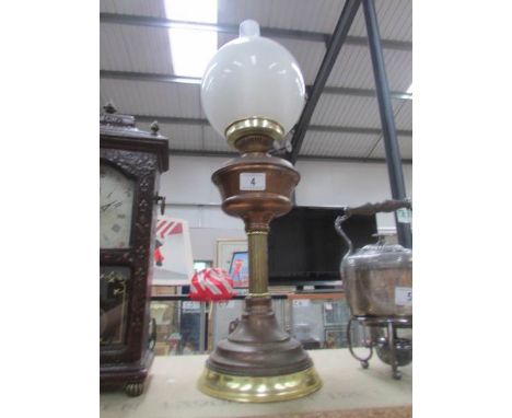 A brass oil lamp complete with shade and chimney.