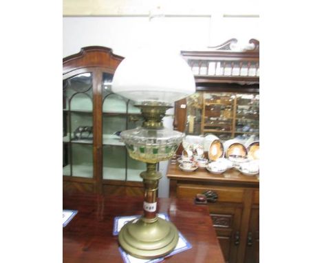 A brass oil lamp with glass font.