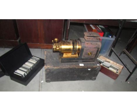 A Victorian magic lantern projector and 3 boxes of glass lantern slides,