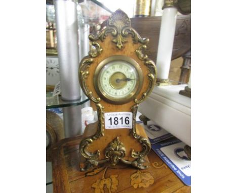 A small clock with metal mounts.