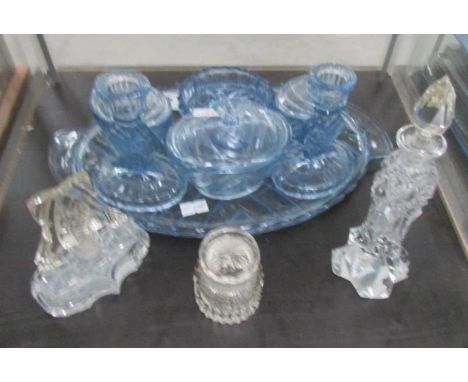 A blue glass trinket set and 3 perfume bottles.