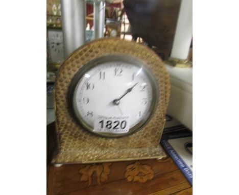 A French mantel clock with snake skin covering.