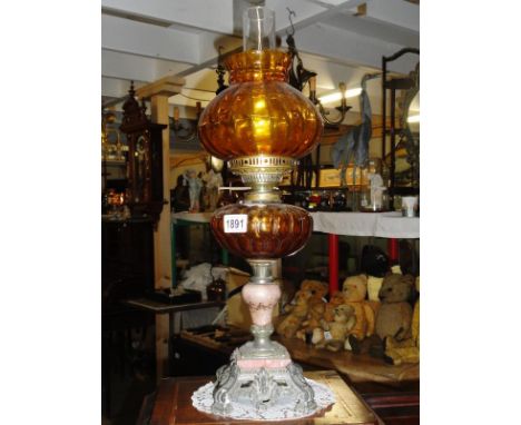 A spelter and marble oil lamp with amber glass font and shade.