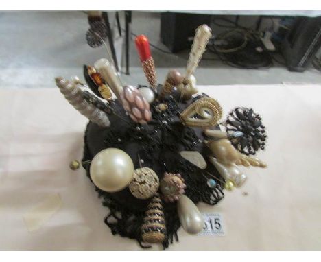 A collection of hat pins on beaded cushion.