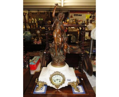 A Victorian marble and gilded mantel clock with four pillars and surmounted by figure.