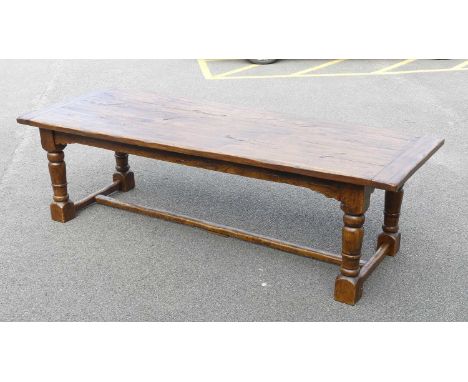 An Elizabethan style oak refectory table, having a planked top with cleated ends, on turned and square cut supports united by