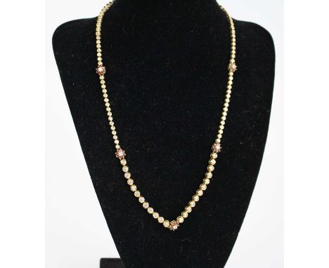 An 18ct gold ruby and diamond articulated link necklet, featuring 75 round brilliant cut diamonds and five clusters each with