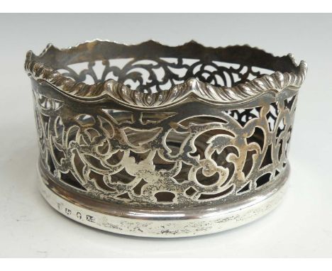An early Victorian silver wine bottle coaster, having a serpentine reeded edge and pierced frieze on a turned mahogany base, 