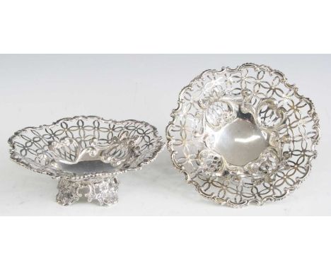 A pair of late Victorian silver bonbon dishes, each of pierced circular form and raised on leaf and flower chased feet, maker