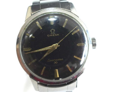 A stainless steel Omega Seamaster manual wind wristwatch, having a round black baton dial and fitted to a three-row bar link 