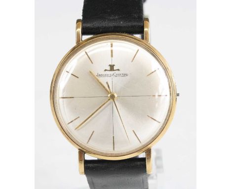 A gents 9ct yellow gold manual wind Jaeger le Coultre wristwatch, having a round silver baton dial and fitted to a black leat
