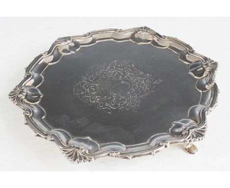 An Edwardian silver card waiter, having a raised piecrust rim, C-scroll and acanthus leaf scroll engraved ground, and raised 