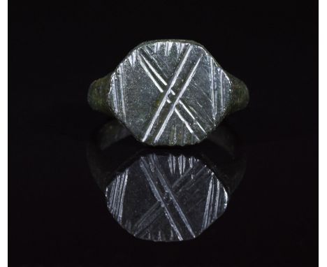 CA. 200 AD. Ancient cast bronze legionary ring with oval hoop; integral round bezel with engraved X pattern; representing num