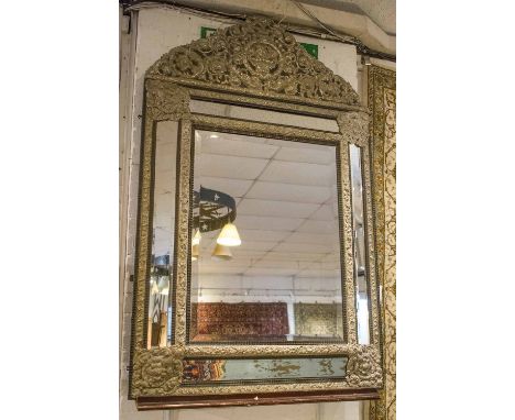 WALL MIRROR, 19th century Dutch silvered brass and ebonised with bevelled plates, Repousse cushion frame and foliate arched c