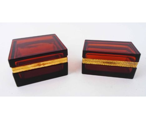 RUBY GLASS CASKETS, two, each with gilt metal mounts, 10.75cm x 10.75cm x 6cm and 11cm x 6.5cm x 5.75cm. (2)