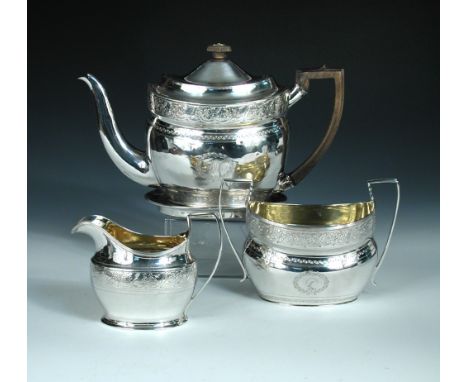 A George III four piece silver tea set by Alexander Field, London 1801, comprising:- an oval teapot engraved with bands of br