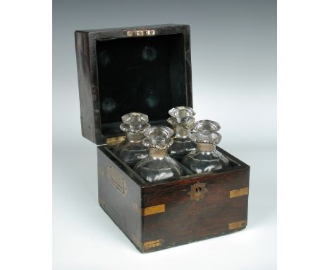 A 19th century brass bound rosewood decanter box, the hinged cover opening to reveal a fitted interior of four stoppered bott