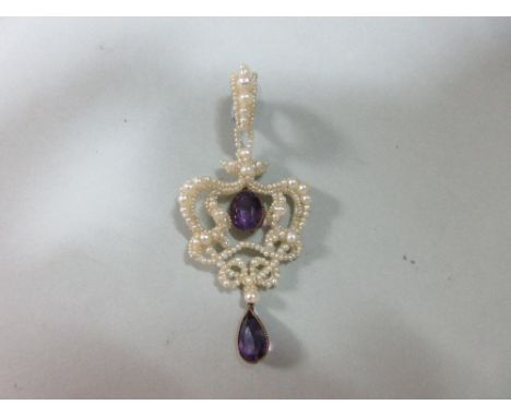 A late 19th century seed pearl work and amethyst pendant, the pierced and scrolling form with graduated fine seed pearls sewn
