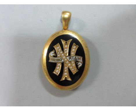 A mid-Victorian enamel and seed pearl memorial locket, the oval pendant with a central 'In Memoriam' panel of seed pearls and