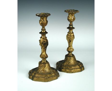 A pair of 19th century ormolu candlesticks, in the Rococo style with scrolling fronds on a scale ground, shaped bases, 29cm (