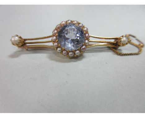 An ice blue sapphire and pearl bar brooch, the large round cut very pale blue sapphire, diameter 11.3cm, in a border of seed 