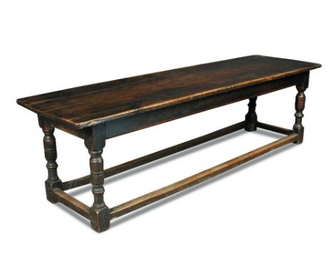 A 17th century oak refectory table, with a pine plank top on turned column legs united by stretchers 77 x 267 x 79cm (30 x 10