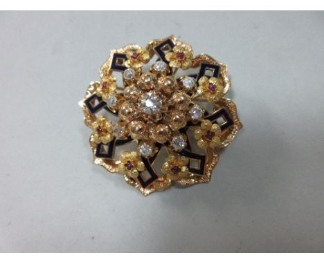 A diamond, ruby and enamel circular brooch, designed as a pierced flowerhead centred on an old round brilliant cut diamond wi