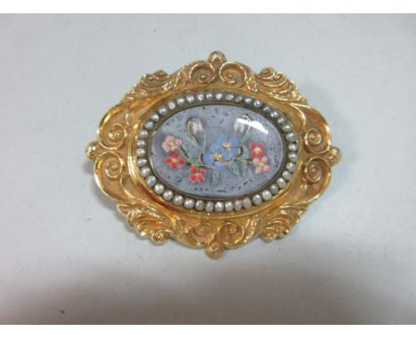 A mid-Victorian brooch/pendant with seed pearls and floral painted panel, the oval glazed panel depicting forget-me-nots, cyc