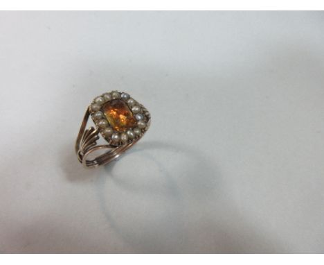 A 19th century ring with a Georgian orange hardstone and seed pearl cluster, the rectangular cushion cut stone, possibly enst